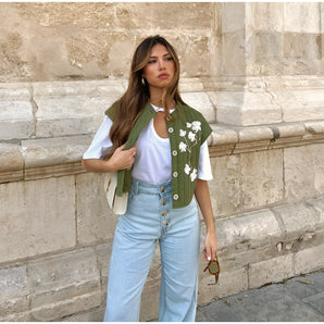 Floral green women's embroidered vest with intricate patterns, worn over a casual streetwear outfit, perfect for spring.