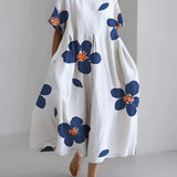 White floral maxi dress in an oversized print, featuring a unique contemporary design, suitable for plus size 5XL. The dress has sleeves and a neckline, and is designed for daytime wear.