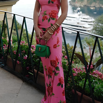 Pink floral mermaid dress with ruffled accents, perfect for garden parties, featuring intricate flower and plant designs, shown on a mannequin with a white background highlighting the dress's elegant neckline and sleeves.