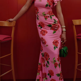 Pink floral mermaid dress with ruffles, designed for garden parties, displayed on a mannequin or model, showing the waist and shoulder details, with a chair in the background.