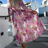 Pink floral midi dress with paisley pattern, featuring long sleeves and a fitted waist, ideal for spring fashion.