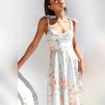 Floral midi dress with pastel garden party theme, featuring short sleeves, a fitted waist, and a knee-length skirt.