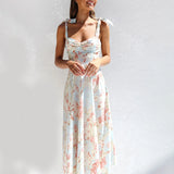 Floral midi dress with pastel garden party print, featuring short sleeves, a fitted waist, and a modest neckline, ideal for vacation or daytime events.