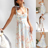 Floral midi dress in pastel colors, featuring a garden party theme, with short sleeves and a fitted bodice. The dress is styled with a white background and floral print, perfect for vacation or casual outings.
