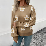 Oversized brown crewneck sweater with a floral daisy pattern, styled casually with jeans.