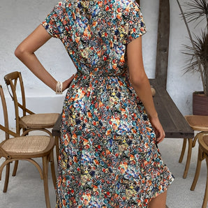 Elegant floral print A-line knee-length summer dress featuring a sleeveless design, suitable for casual or semi-formal occasions, displayed on a mannequin or model with styled hair, surrounded by greenery such as houseplants in the background.