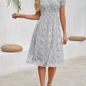 Women's knee-length A-line cotton dress featuring a floral print, styled for spring fashion. The dress is modeled with focus on the outfit, highlighting its one-piece garment structure with visible arms and legs. The dress appears predominantly white with floral patterns.