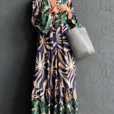 Floral Print Long Sleeve Button-Front Maxi Dress in Blu Tropicale color, highlighting the elegant green floral pattern, long sleeves, and button-front design. The dress features a fitted waist and flowing maxi length, perfect for a stylish and casual chic look.