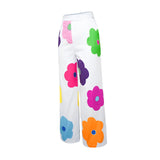 High-waisted women's summer trousers with a floral print in shades of violet and magenta.