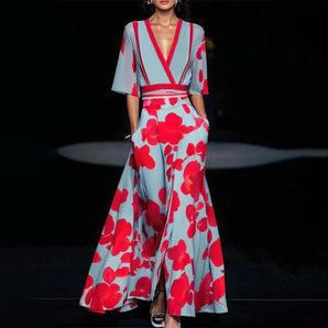 Elegant designer floral print red V-neck palazzo jumpsuit with waist detailing and short sleeves, showcasing a fashionable one-piece garment suitable for day wear.