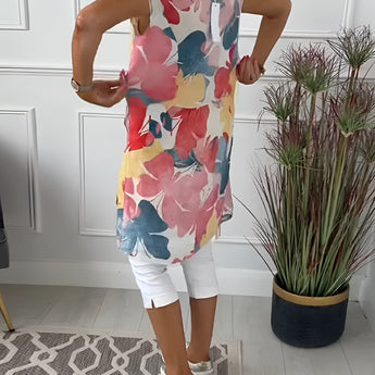 Sleeveless summer tunic top for women featuring a vibrant floral print, highlighting the shoulders and waist.