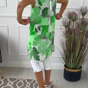 Floral print sleeveless summer tunic top for women featuring a vibrant green background with colorful floral patterns, designed with a relaxed fit and a round neck.