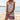 Woman wearing a pink floral print V-neck sleeveless beach dress in 3XL, standing by the water with a clear sky in the background, showing the lightweight bohemian sundress flowing around her thighs.