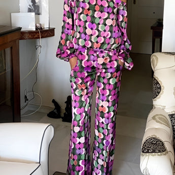 
A purple and black floral print women's off-shoulder jumpsuit designed for luxury evening wear, featuring long sleeves and an elegant neckline in size XL.