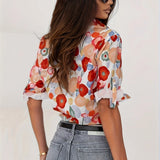 Floral silk blouse in a vibrant spring pattern, featuring long sleeves and a soft, flowing design.