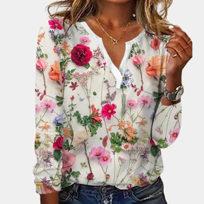 A lightweight chiffon floral V-neck blouse in white with long sleeves, featuring a pink floral pattern, shown in size XL.