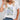Floral V-neck women's T-shirt in dark green, featuring a white design with eco-friendly fabric, displayed on a mannequin showcasing the neckline and fashion details.