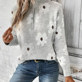 Woman wearing a Floral Wool High-Neck Sweater in Cozy Gray, paired with jeans, showcasing winter knitwear fashion.