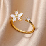 Elegant gold floral engagement ring featuring a flower-shaped diamond design with intricate petal details.