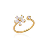 Gold floral engagement ring with a flower-shaped diamond, featuring a round clear stone, elegant botanical design.