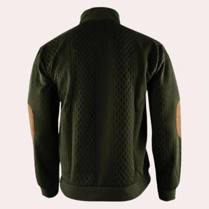 Men's forest green wool cable knit sweater with elbow patches, featuring a high neckline and long sleeves.