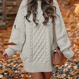 A woman wearing a forest green oversized cable knit sweater dress with a cozy turtleneck, showcasing a stylish and comfortable fashion choice.