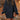 
A woman wearing a forest green oversized cable knit sweater dress with a cozy turtleneck. The dress features a loose fit and long sleeves, perfect for a casual and stylish look.