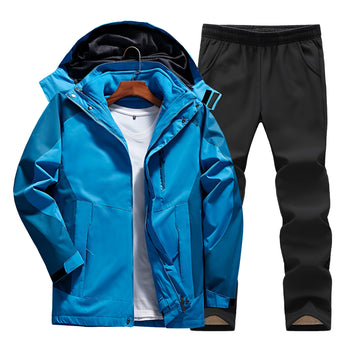 Men's hooded track jacket in fuchsia with long sleeves and a collar, paired with black moisture-wicking pants, displayed in a vibrant blue color. The jacket features pockets and is designed for sportswear use. The ensemble is suitable for athletic activities or casual wear.