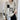 Women's fashion sweater with a geometric checkerboard pattern, featuring a crewneck style and long sleeves. The sweater is primarily white and designed as a one-piece outerwear garment, highlighting modern and stylish fashion elements.