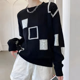 White geometric checkerboard knit crewneck sweater with long sleeves, featuring a stylish fashion design for women's wear.