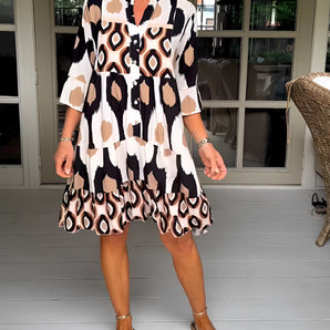White geometric pattern V-neck bell sleeve mini dress, showcasing summer fashion with a focus on the neckline, flowing sleeves, and fitted waist.