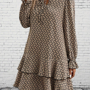 Woman wearing a geometric print boho chic V-neck long sleeve mini dress with a ruffle hem, featuring black and white patterns.