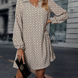 Woman wearing a geometric print long sleeve mini dress with black and white tartan pattern, standing and posing with hands on hips.