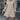 Woman wearing a beige geometric print long sleeve mini dress, showcasing casual chic fall fashion.