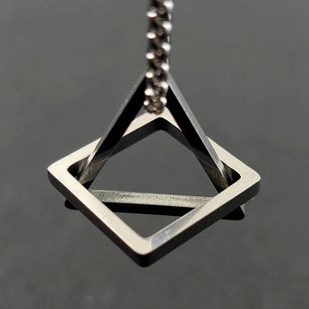 Geometric silver square frame pendant on a modern minimalist necklace, featuring a symmetrical and sleek metal design, resembling an open picture frame.