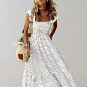 Gingham maxi dress with a square neckline, smocked bodice, and ruffle trim, featuring short sleeves and a fitted waist.