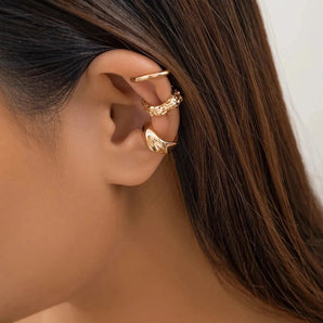 Close-up of a woman's ear adorned with elegant gold diamond-studded hoop earrings, showcasing luxury fashion jewelry.