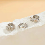 Gold Diamond-Studded Hoop Earrings displayed on a beige background, showcasing luxury fashion jewelry for women with intricate metal detailing and sparkling diamonds.