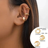Gold diamond-studded hoop earrings with a textured polished finish worn by a woman.