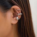 Close-up of a woman wearing gold diamond-studded hoop earrings with visible facial features including forehead, hair, nose, lips, chin, and eyebrow.