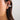 Silver huggie hoop earrings with pave setting, adorned with diamonds, worn on the ear of a woman.