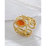 Gold filigree bracelet featuring an orange gemstone, showcasing intricate design and luxurious craftsmanship.