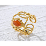 Gold filigree bracelet with an orange gemstone, intricate design, luxury jewelry, amber and gold tones.