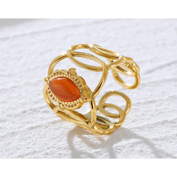 Gold filigree bracelet with an orange gemstone, intricate design, luxury jewelry, amber and gold tones.