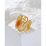 Gold filigree bracelet with an orange gemstone, featuring intricate design and luxurious craftsmanship.