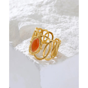Gold filigree bracelet with an orange gemstone, featuring intricate design and luxurious craftsmanship.
