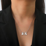 Gold hand heart necklace with a pendant showcasing a romantic love gesture, worn around the neck, featuring a delicate chain and fashionably displayed on a person's chest.