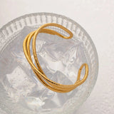 Gold heart bracelet with adjustable minimalist open heart bangle design on a white background.