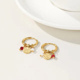 Gold hoop earrings with dangle pearl and textured disc charms, designed by YA-CHAN, showcasing a combination of natural materials and intricate metalwork.