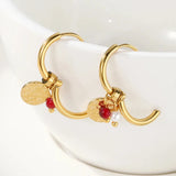 Gold hoop earrings featuring dangle pearl and textured disc charms, designed by YA-CHAN, made of metal and natural materials.
